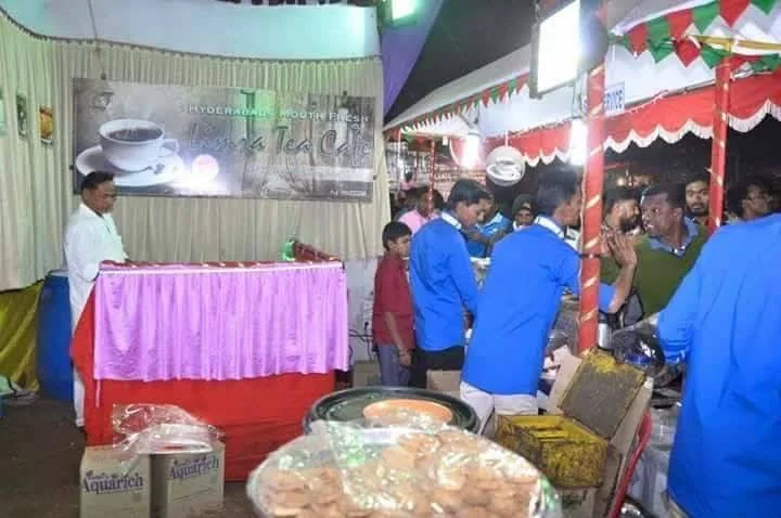 The Limra Tea Café counter with a tray of biscuits in the foreground and staff serving customers